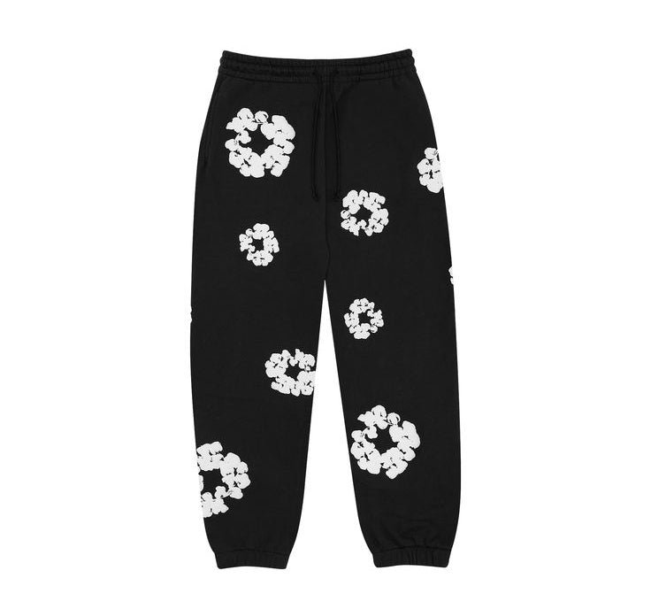 Black sweatpants with white floral patterns on a white background
