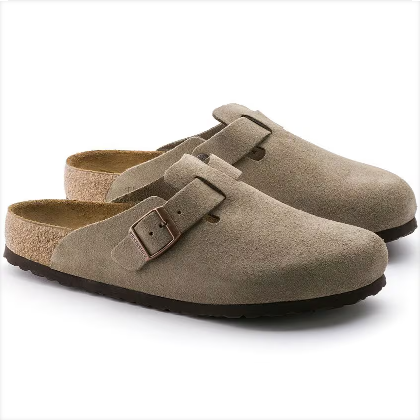 Pair of beige suede clogs with a buckle on a white background